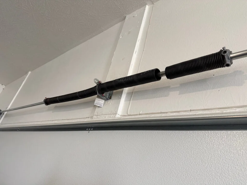 Broken garage door torsion spring with a visible gap, repaired by Garage Door Pro in Carmel, IN